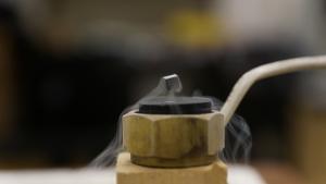 Small cube-shaped magnet hovering over a supercooled superconductor