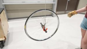 Spinning bicycle wheel with axle on hook