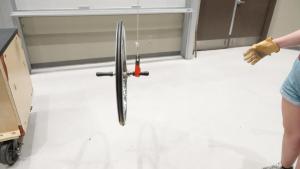 Spinning bicycle wheel with axle on hook