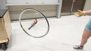 Spinning bicycle wheel with axle on hook