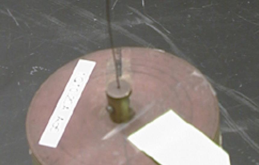 A disk hanging from a wire oscillates.
