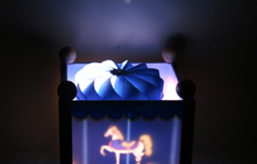 Air heated by a lamp turns the carousel by convection.