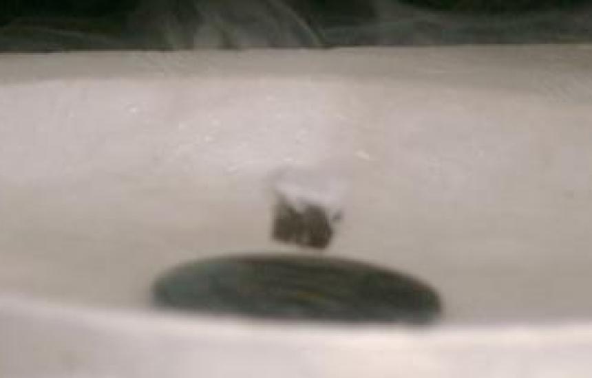 A magnet levitates above a super cooled ceramic superconductor.