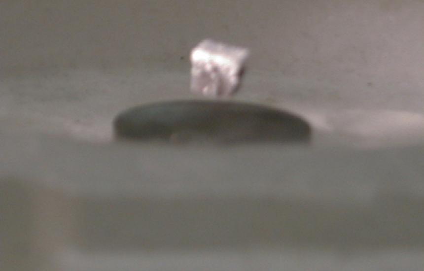 A magnet levitates above a super cooled ceramic superconductor.