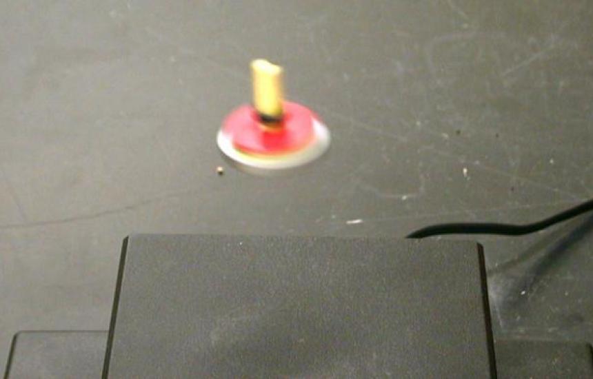 A spinning magnet levitates above a permanent magnet.
