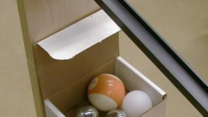 A box with different balls for the v-shaped track